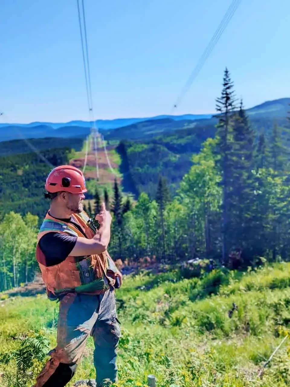 Travailleur dans une emprise de ligne électrique en montagne